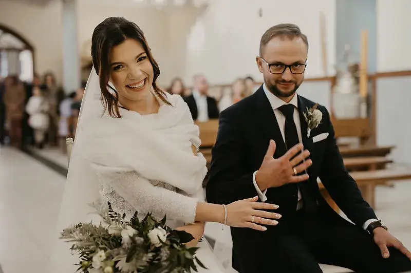 Para młoda podczas ceremonii ślubnej pokazuje obrączki po zarezerwowaniu terminu i usługodawców Para młoda podczas ceremonii ślubnej pokazuje obrączki po zarezerwowaniu terminu i usługodawców